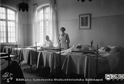 Vårdavdelning på St Lars i Lund
Kapsel 22 med bilder från St Lars i Lund. Sänglägesbehandling c:a 1929 (Halva 16 pers. salen). Originalfoto, ateljé Alfr Hagblom, Lund. Troligen 1920-1930-talen (1929?). Monterat.
Nyckelord: Kapsel 22;St Lars;Lund;Patienter;Behandling;Interiör