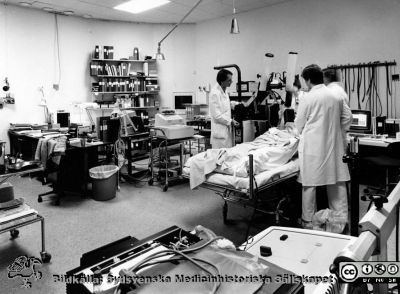 Onkologiska kliniken i Lund i slutet på 1980-talet
Foto Ola Terje låda A bild 9/12. Hypertermibehandling. Fysiker Per Nilsson till vänster, Gull-Maj Aldén närmast kameran och dr Claes Ebbe Lindholm till höger. 
Nyckelord: Terje;1980-talet;Onkologi;Klinik;Interiör