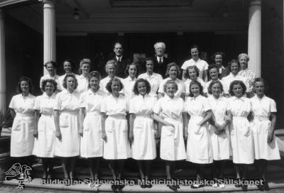 Sjukgymnastkurs i Lund från mitten på 1900-talet.
Påskrift: "Sjukgymnastutbildning". Foto Tykesson (Lund). Sjukgymnastinstitutets inspektor, prof. Torsten Thunberg till vä i bild, bakom sjukgymnasterna. Institutets chef, major J. G. Thulin till höger. 
Anna Tykesson drev en fotoateljé i Lund 1924 - 1945, så bilden är från denna epok.
Nyckelord: Sydsvenska;Gymnastik;Institutet;SGI;Examen;Gruppfoto;Fotografi;Anna Tykesson;Lund;Torsten Thunberg;major;Josef;Thulin