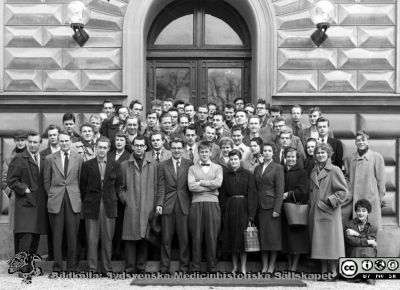 Kursfoto, medicinarnas nybörjarkurs vårterminen 1956 i Lund
Kapsel 27. Fotoarkiv. Anatomiska instutionen. Kursfotografier från 1950- och 1960-talen. Vårterminen 1956. Originalfoto på anatomiska institutionens trappa. Troligen Bo Eklöf i ljus tröja i första radens mitt, och Bengt Åke Lindhe på hans högra sida. B.G. Svensson som nr 2 från vänster i första raden, Håkan Odeberg allra längst till höger och Birgitta Borulf sittande framför honom. Bo Lilja i bakgrunden till höger i bild.
Nyckelord: Kapsel 27;Kursfoto;Anatomi;Amphioxer