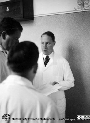 Kanske rond på kvinnokliniken i Lund år 1936
Kapsel 28. Bild från kuvert märkt "Fotografier tagna av Elof Munck under studieåren på 1930-talet" och i innerkuvert märkt "Sommaren 1936 BB i Lund". Ingen påskrift på bilden. Man ser dock troligen Hans Kottmeier framifrån, kanske Axel Westmans hjässa, panna och högra öga samt möjligen Gunnar Gortons nacke. Originalfoto. Omonterat. Originalfoto. Omonterat.
Nyckelord: Kapsel 28;1930-talet;BB;Lund