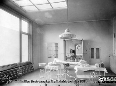 Operationsrum på kirurgiska klinikens i Lund 1906
Kapsel 29. Påskrift: "Det finns 2 operationsrum på gamla kirurgen. Llampan var icke höj- och sänkbar. I skåpet steriliserades instrumenten. Originalfoto Lina Jonns Eftr 1906 (Per Bagge). Monterat
Nyckelord: Kapsel 29;Lasarettet;Lund;Kirurgi;Operationssal