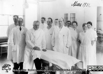 Prof. Gustaf Petrén på kirurgiska kliniken i Lund på en operationssal. Originalfoto
Kapsel 29. Ingen tolkbar påskrift annat än "Mars 1931". Läkarna från vänster, troligen: Åke Rydén och Yngve Plym-Forshell. Sedan professor Gustaf Petrén och Nils Liedberg och slutligen troligen Seved Bergendal Alla står på kirurgiska kliniken i Lund på en operationssal. Originalfoto. Ej monterat
Nyckelord: Kapsel 29;Kirurgisk;Klinik;Lund