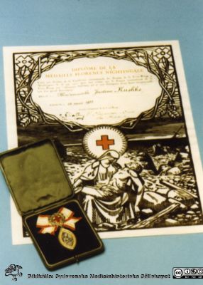 Florence Nightingale-medaljen med tillhörande diplom
Kapsel 30. Omärkt bild visande Florence Nightingale-medaljen med tillhörande diplom, utdelat till Mademoiselle Justine Kushke 1931. Originalfoto. 	Ej monterat
Nyckelord: Kapsel 30;Medalj;Diplom;Hederstecken