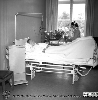 Vårdsal på 1950-talet
Pärm äldre neg. 1951-1958 MAS i lasarettsfotograf Björn Henrikssons samling. Patientsal på Malmö Allmänna Sjukhus med SSSH-sköterska. Ställningen över patientens ben antyder att bilden troligen är tagen på ortopediska eller kirurgiska kliniken.
Nyckelord: Vårdsal;MAS;1950-talet;Malmö;Sköterska;SSSH