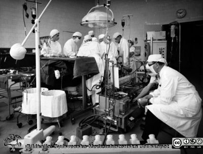 Operation med konstgjort hjärta i Malmö
Pärm neg. 1958-1962 MAS. Från fotograf Björn Henrikssons samling. Påskrift: "Kir OP, hjärt-lungmaskin OP". Operation med hjärt-lungmaskin av den typ som användes efter den första med bubbeloxygenator. Från negativ. Finns också som bild SMHS8322, från Olle Lundskogs fotoalbum och som bild SMHS8692.
Nyckelord: UMAS;MAS;Malmö_;Allmänna;Sjukhus;Kirurgi;Operation;Hjärt-lungmaskin