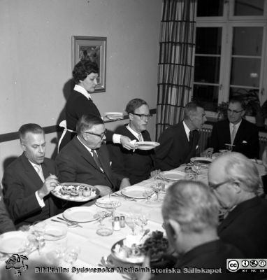 Från invigningen 24/11 1961 av ögonklinikens nya byggnad i Malmö
Pärm neg. 1958-1962 MAS. Från fotograf Björn Henrikssons samling. Påskrift: "Ögon klin, invigning, 24/11-61". 
Dir. Willy Danborg längst till vä. Servitrisen ger just prof. Jan Waldenström soppa. Från negativ
Nyckelord: UMAS;MAS;Malmö_;Allmänna;Sjukhus;Invigning;Ögon;Fest