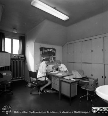 Sköterskeexpedition och förråd på operationsavdelningen på gamla öronkliniken i Malmö
Pärm negativ MAS 1972-1977. Från fotograf Björn Henrikssons samling. Omärkt bild, öronkliniken Malmö Allmänna Sjukhus. Förråd, öron op. S. Christina Flodén med okänd. Från negativ
Nyckelord: UMAS;MAS;Malmö;Allmänna;Sjukhus;Öron;Öronklinik;ÖNH;Oto-rhino-laryngologi