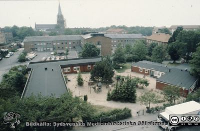 Barndaghemmet Röda stugan 1990
Ur låda med blandade diabilder från sjukhusfotograferna i Lund, 1970-, 1980- och 1990-talen.  Barndaghemmet Röda stugan 1990, alldeles före rivning / demontering och flytt till parken öster om Ögon B. Allhelgonakyrkan har byggnadsställningar runt tornet. Foto från någon av de övre våningarna på dåvarande barnkliniken. Fotograf: Ingemar Nilsson.
Nyckelord: Lasarettet;Lund;Universitetssjukhuset;USiL;Daghem;Barn;Röda Stugan