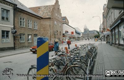 Stora Södergatan i Lund norrut mot Stortoget1993.
Ur låda med blandade diabilder från sjukhusfotograferna i Lund, 1993.  Trappgavelhuset bildens mitt är Stäket.
Nyckelord: Lund;Stad;Gata;Fasad;Cyklar;Torg;Affärer