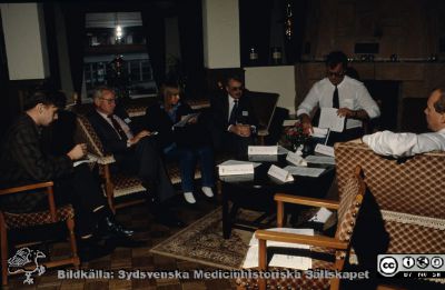 Lasarettet i Lund. En grupp politiker och tjänstemän i aktion
Från en låda med blandade diabilder från 1970- 1980- och 1990-talen. På namnskyltarna bl.a. Kay-Vilhelm Winquist (nr 2 från vä), Viking Tell, Jörgen Malmberg, Michael Wendeberg? Jörgen Gustafsson. 
Nyckelord: Lund;Lasarett;Universitetssjukhus;Universitet;USiL;Politiker;Möte;Konferens