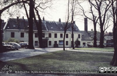 Norra fasaden på kurhuset vid Paradisgatan + servicehus med skorsten
Ur låda med blandade diabilder från sjukhusfotograferna i Lund, troligen 1900-talets mitt. Bild utan beskrivning, i gammal Agfa helglasram.
Nyckelord: Lasarett;Lund;Universitet;Universitetssjukhus;USiL;Hud;Dermatologi;Venereologi