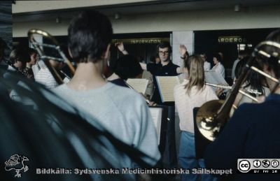 Lasarettet i Lund på 1970-talet. Ungdomsorkester spelar i entréhallen i C-blocket
Pärm Diabilder UNS 1970-talet. Bild utan påskrift. Ungdomsorkester spelar i entréhallen i C-blocket. Fokus på dirigenten. Bistron har ännu inte byggts upp. Från diapositiv.
Nyckelord: Lasarett;Lund;Universitet;Universitetssjukhus;USiL;Centralblocket;Entré;Orkester;Ungdom