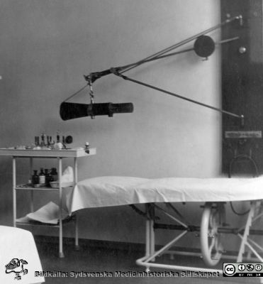 Operations- eller behandlingsrum på ögonkliniken i Lund i mitten på 1920-talet
Operations- eller behandlingsrum på ögonkliniken i Lund i mitten på 1920-talet. Vid väggen ett höj- och sänkbart operationsbord. Ovanför en elektrisk apparat av något slag, en fokalbelysningslampa?
Nyckelord: Operationsrum;Behandlingsrum;Ögonklinik;Lasarettet i Lund