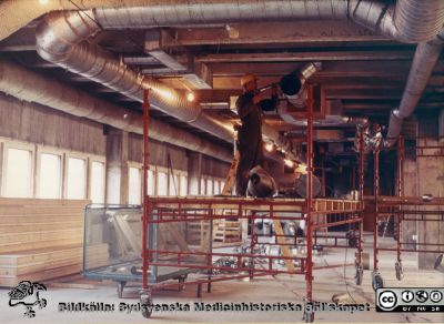 Centralblocket i Lund byggs 
Ventilationsrör mm dras under tak vid bygget av centralblocket på Lasarettet i Lund. En av c:a 40 byggbilder i ett album gjort av byggfirman SIAB från bygget av C-blocket i Lund 1964 - 1967 och tillägnat professor Olle Olsson. Denne var en av de starkaste cheferna på sjukhuset vid denna tid.
Nyckelord: Lasarettet;Lund;Universitetssjukhuset;USiL;Centralblocket;Bygge