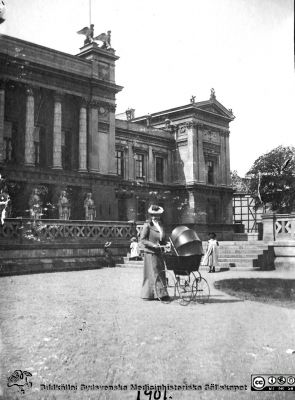 Lisa Essen-Möller på promenad på Universitetsplatsen i Lund 1901
Lisa Essen-Möller på promenad på Universitetsplatsen i Lund 1901 med sonen Erik Essen-Möller i barnvagnen. Publicerad på sid. 18 i Westling (2010). Bildkälla: Håkan Westling.
Nyckelord: Lasarettet;Lund;Universitetssjukhuset;USiL;Gynekologi;Psykiatri