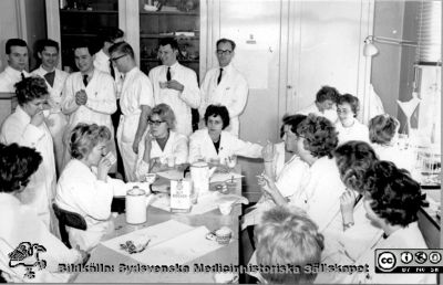 Patologiska institutionen på Paradisgatan före 1962.
Ur CG Ahlströms album Institutionen för Patologi, Paradisgatan, Dess chef och personal 1944 - 1962. Kaffekalas (kanske i luciatid) i slutet på 1950-talet. Stående i bakre raden från vänster: Tom Saldeen, okänd, Nils Jonsson, skymd person, Ulf Mercke, okänd (möjligen Måns Åkerman) och Nils Stormby. 
Text invid på albumbladet.
Sällan har skådats ett ställe så proppfullt
som denna boning vi kalla för vår
chefen han tycker att läget är hoppfullt
det har han tyckt i en 7 - 8 år.
Kanske en gång blir det dockav all möda
en Patolog som är nybyggd och fin.
Alla som sitter här nu är då döda
finns blott i burkar med formalin.
Nyckelord: Lasarettet;Lund;Universitetssjukhuset;USiL;Patologiska;Institutionen;Avdelningen;Anställda;Personal;Luciafest