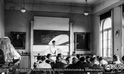 Föreläsningssalen på Patologiska institutionen i Lund i mitten på 1900-talet, senast 1962
Ur CG Ahlströms album "Institutionen för Patologi, Paradisgatan, Dess chef och personal 1944 - 1962". "Föreläsningssalen". Docent Unne Stenram föreläser.
Nyckelord: Lasarettet;Lund;Universitetssjukhuset;USiL;Patologiska;Institutionen;Avdelningen;Föreläsning