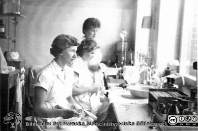 Avdelningen för klinisk kemi i Lund. Laboratoriepersonal i arbetei mitten på 1900-talet
Bilder på A1-ark f. klin-kem jubileum 1997. Gammal bild utskriven med bläckstråleskrivare som gjorde den randig. En grupp biträden rengör objektglas. Foto rimligen i mitten på 1900-talet.
