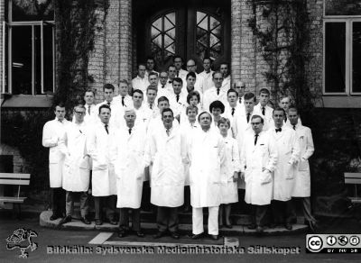 Medicinarkursen i kirurgi i Lund vårterminen 1962
1: Christer Owman. 3: Curt? Åberg. 4: Prof. Philip Sandblom. 5: Doc. Carl Axel Ekman. 6: Ingrid Pettersson Frolow. 7: Doc. Olle Dahlbäck. 8: Gertrud Helmersson. 9: Anders Sellman. 10: Claes-Ebbe Lindholm. 11: Lars Ekeroth. 12: Tibor Koleszar. 13: Mats Willstrand.14: Bengt-Olof Kallum. 15: Arne Melander. 16: Ulla Bergentz Hedner (f. Flodmark). 17. Okänd. 18: Stig Bäckström. 19: Bengt Björkstén. 20: Rikard Carlsson.  22: Sven-Erik Svensson. 23: Gillis Johansson.  24: Hans Thysell. 26: Doc. Göran Lundh. 27: Dr. Erland Sartor. 28: Bengt Scheele 29: Sven Kornfält. 32: Sven Lenninger? 35: Dr. Bengt-Åke Åkesson.
Omonterat fotografi.
Nyckelord: Lasarettet;Lund;Universitetssjukhuset;USiL;Kapsel 04;Kirurgisk;Klinik;Kurs