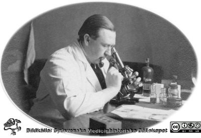 Fotoalbum tillägnat Professor Torsten Hellman från lärjungar under Kursen 1924 - 25
Fotoalbum tillägnat Professor Torsten Hellman från lärjungar under Kursen 1924 - 25. En icke identifierad man i laboratorierock (troligen en kursamanuens) vid ett mikroskop på histologiska avdelningen vid anatomiska institutionen. Det står Aceton på den stora flaskan i bakgrunden. Ingen bildtext.
Bildkälla Stiftelsen Locus Medicus Lundensis 250317. Fotograf okänd.
Nyckelord: Histologiska avdelningen;Anatomiska Institutionen;Medicinska fakulteten i Lund;Sydsvenska Medicinhistoriska Sällskapet;Locus Medicus Lundensis;Lärare;Elever