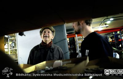 Medicinhistoriska Magasinet i februari 2009 under ambulansgaraget vid USiL. 
Alla tiotusentals saker lagrade i gamla Orupssjukuset är hitflyttade, och gallring pågår av arkivarier från Kulturen i Lund. På bilden ses orotpeden Jan Larsson vid ett besök för att hjälpa till att identifiera föremål. En arkivarie (Mats Engström) tittar på.
Nyckelord: Medicinhistoriskt;Magasin;USiL;Lasarettet;Universitetssjukhuset;Lund;Kulturen;2009;Lund;Berndt;Ehinger;Mats;Engström