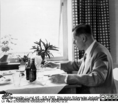 Ögonläkarmöte i Lund 4/6 - 5/6 1955
Vid lunchbordet Stig Holm, en av 1950-talets färgstarkaste ögonläkare, förbereder debatten. Han var ursprungligen utbildad i Lund, och disputerade på en avhandling om myopi bland afrikanska negrer, tillkommen under och efter några års arbete hos den kände Albert Schweitzer i Lambarene i Afrika. Sedermera var han huvudsakligen verksam som privatpraktiker i Göteborg. Två av hans söner blev också ögonläkare, Olle och Mårten. Ur Paul Enokssons fotoalbum. Fil 980407a.tif.
Nyckelord: _Ögon;_Ögonkliniken;_Ögonläkare;Lunds universitet;Lasarettet i Lund;Medicinska fakulteten;Nordiskt