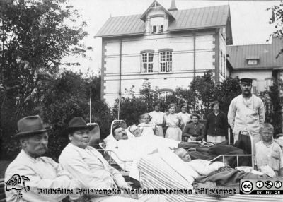 Patienter i en sjukhuspark, troligen på Malmö Allmänna Sjukhus
Bild 10 i husmor Anna Landelius (1880-1964) efterlämnade fotoalbum. Ingrid Frennhoff (f. 1944) hade övertagit detta album efter sin morfar som i sin tur tagit hand om det efter sin syster husmor Anna på Lasarettet i Lund. Gåva till Sydsvenska Medicinhistoriska Sällskapet nyåret 2020.- Malmö Allmänna Sjukhus huvudbyggnad syns i bakgrunden.
Nyckelord: SSSH;Sjukhuspark;Malmö Allmänna Sjukhus;MAS;Patienter