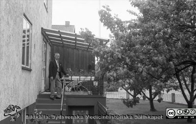 Styrelsemedlemmen revisor Eric Sundmark på trappen till ett flervåningshus med trädgård, rimligen i Karlskrona. 
Foto i John och Augusta Perssons stiftelses arkiv. Styrelsemedlemmen revisor Eric Sundmark på trappen till ett flervåningshus med trädgård, rimligen i Karlskrona. Identifieringen av Sundmark godtagen av Dick Killander 2022-03-14. Digitaliserat från omärkt negativ. Foto på 1960-talet, kanske med Kurt Lidéns kamera.
Nyckelord: John och Augusta Perssons stiftelse;Medicinska fakulteten;Lunds universitet;JAP