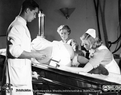 Docent Göran Bauer injicerar 1953 i Malmö kontrastmedel ("Kontrast U Leo") i spinalrummet för myelografi.
Docent Göran Bauer injicerar 1953 kontrastmedel ("Kontrast U Leo") i spinalrummet för myelografi. Samma bild som i fil SMHS7523 från pärm äldre neg. 1951-1958 i fotograf Björn Henrikssons samling. Foto John Erik Fritzin, Malmö Allmänna Sjukhus.
Foto från samling funnen på vinden på KK i Lund hösten 2016 och tillvaratagen av sekreteraren Elisabet Gyllander där i samband med att hon gick i pension och överlämnat samlingen till Sydsvenska Medicinhistoriska Sällskapet. 
Nyckelord: MAS;Malmö;Kirurgi;Ortopedi;Röntgen;Myelografi;Allmänna;Sjukhus;UMAS;Universitetssjukhus