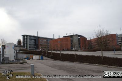 Lasarettet i Lund, mars 2012
Från vänster cisterner vid 1950-talets ambulansgarage,  norra delen av BMC-längan och sedan parkeringshuset Ovalen och nya barnkliniken. Foto mot öster från Systervägen vid ambulansgaraget.
Nyckelord: Lasarettet;Lund;Universitetssjukhuset;USiL;Parkeringshus;Barnklinik;BMC