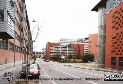 Universitetssjukhuset SUS Lund, 2012. Klinikgatan. BMC till vänster, parkeringshuset Ovalen till höger.
Universitetssjukhuset SUS Lund, mars 2012. Vy söderut längs Klinikgatan. Biomedicinskt Centrum (BMC) till vänster, ögonkliniken A i fonden, C-F-blocken, barnkliniken BUS och parkeringshuset Ovalen till höger.
Nyckelord: BMC;Barnsjukhus;BUS;_Ögonklinik;Centralblocket;Parkeringshus