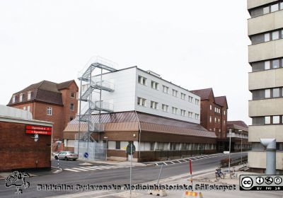 Universitetssjukhuset SUS Lund, mars 2012.
 Vy västerut längs Klinikgatan vid ögonkliniken A och akutmottagningen.Kvinnokliniken mellan dessa båda.
Nyckelord: Ögonklinik;KK;Kvinnoklinik;BB;Förlossningsavdelning;Akutmottagning;Centralblocket;Lund;Universitetssjukhuset;USiL