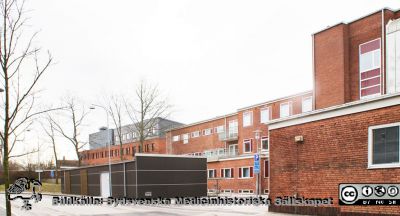 Universitetssjukhuset SUS Lund, mars 2012.
 Vy öDsterut längs Klinikgatan vid ögonkliniken A och akutmottagningen.Den mörka lådliknande baracken är för distribution av medicinska gaser. Zoofysiologiska institutionen i bakgrunden.
Nyckelord: _Ögonklinik;Akutmottagning;Centralblocket;Lund;Universitetssjukhuset;USiL;Zoofysiologisk;Institution