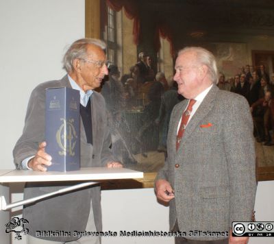 Bengt I. Lindskog tackar Nils-Otto Sjöberg för hans insatser för Skåne-SÄL
Bengt I. Lindskog tackar Nils-Otto Sjöberg för hans insatser för Skåne-SÄL och förärar honom en flaska champagne för detta vid Skåne-SÄLs möte 2021-10-12. Överräckandet skulle ha gjorts vid 20-års-jubileumsmötet 21-09-14 men fick göras vid detta möte i stället. Det blev dubbel hyllning för Nils-Otto.
Nyckelord: Föreläsning;Jubileum;20år;Hyllning;Dubbel;Jubileum