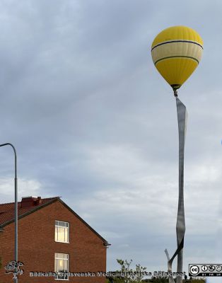 2023 års nya version av Arne Jones' staty "Vertikal komposition" lyfts på plats 2023-08-30 med varmluftsballong
2023 års nya version av Arne Jones' staty "Vertikal komposition" lyfts på plats 2023-08-30 med varmluftsballong enligt fotografen Lars Malm när han premiärvisade bilden på årsmötet med Sydsvenska Medicinhistoriska Sällskapet 2024-04-22. Åhörarna uppskattade starkt och ljudligt bilden. Ursprungliga fysiologiska institutionens östergavel syns i bildens nedre vänstra hörn. Den ingår nu i det nya byggnadskomplexet Forum Medicum vid medicinska fakulteten i Lund.
Nyckelord: Skulptur;Fysiologiska;Institutionen;Medicinska fakulteten;Lunds universitet;Forum Medicum;Installation;Resning