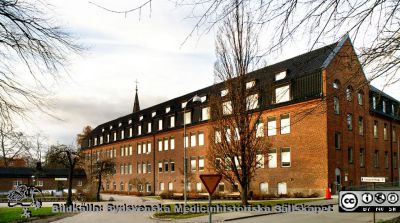 1918 års kvinnoklinik i Lund 
Foto en eftermiddag i slutet av november 2013 med solen lågt på himlen. Fasader mot söder och öster Allhelgonakyrkans torn i bakgrunden..
Nyckelord: Kvinnoklinik;Lund;Lasarett;Universitet;Universitetssjukhus;USiL;KK;Gynekologisk;Klinik