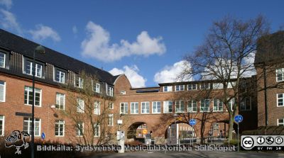 Gamla internmedicinska kliniken från 1918 (nu hudhuset) med valvbågar öaterut. Foto 22 mars 2020.
Gamla internmedicinska kliniken från 1918 (nu hudhuset) med valvbågarna över till reumatologiska kliniken.
Nyckelord: Intern Mediicin;Klinik;Reumatologiska kliniken;Valvbågar