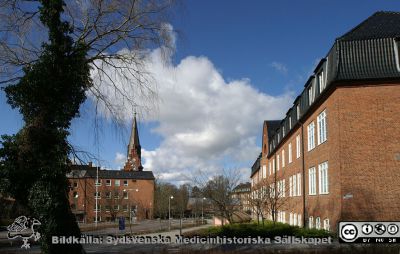 Gamla kvinnokliniken och förlossningsavdelningen till vänster, nu Rehabhuset. Gamla internmedicinska kliniken till höger, nu Hudhuset. Allhelgonakyrkan i mitten. 
Gamla kvinnokliniken och förlossningsavdelningen till vänster, nu Rehabhuset. Allhelgonakyrkans torn i mitten. Gamla internmedicinska kliniken till höger, nu Hudhuset. Foto 2020-03-22.
Nyckelord: Kvinnoklinik;Gynekologisk klinik;Barnbördsavdelning;Allhelgonakyrkan;Intern Mediicin;Hudhuset;Rehabhuset