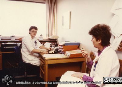 Ortopediska kliniken i Lund 1986. T. v. Klinikföreståndare Sylvia Olander och sekreterare Cristel Hörstedt. 
Från ortoped klin album 01, Lund. Fotograf Berit Jakobsson.  1986. T. v. Klinikföreståndare Sylvia Olander (sjuksköterska) och hennes sekreterare Cristel Hörstedt. Ortopeden.
Nyckelord: Lund;Universitetssjukhus;USiL;Kliniker;Ortopedi;Personal;Sjuksköterska;Klinikföreståndare