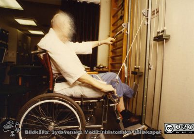 Ortopediska kliniken i Lund 1986. Pataent som tränar sin armstyrka.
Från ortoped klin album 01, Lund. Fotograf Berit Jakobsson.  1986. Pataent som måst amputera vänster underben. Han tränar sin armstyrka för att kunna köra sin rullstol bra.
Nyckelord: Lund;Universitetssjukhus;USiL;Kliniker;Ortopedi;Patienter;Amputationer