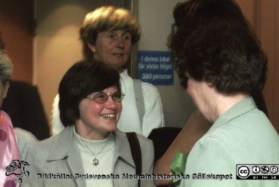 Ortopediska kliniken i Lund 2000.Vårdadministratören Berit Jakobsson avtackas i sjukhusaulan.
Från ortoped klin album 01, Lund. Fotograf Berit Jakobsson. 2001. Sjukgymnasten Ingrid Åström och sjuksköterskan Daisy Andersson minglar i sjukhusaulans nedre foajé i samband med framförandet av  Henning Mankells monolog "Grävskopan" med Tommy Borgström från Ystads Stående Teatersällskap, specialskriven för honom. Föreställningen gavs  inför klinikens personal som avtackningspresent till klinikföreståndaren och vårdadministratören Berit Jakobssonl.
Nyckelord: Lund;Universitetssjukhus;USiL;Kliniker;Ortopedi;Personal;Fysioterapeuter;Sjuksköterskor