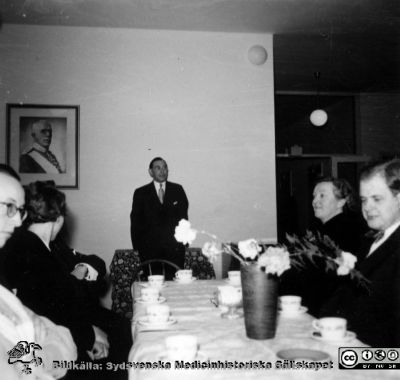 Kaffekalas på jubileums- / radiologiska kliniken i Lund. 
Klinikchefen docent Bertil Ebenius håller tal. Kanske är det i samband med Martin Lindgrens disputation 1958, för flera bilder i närheten i Elina Lundborgs album är från det evenemanget. Från Syster Elinas fotoalbum (Elina Holmberg?).
Nyckelord: Jubileumsklinik;Radiologisk;Klinik;Onkolkogisk;Disputation;Lasarettet i Lund;Universitetet i Lund