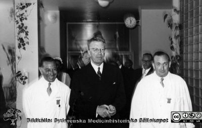 Kungligt besök på radiologiska kliniken i Lund 1952. 
Hans Majestät Konung Gustav VI Adolf besöker radiologiska kliniken i Lund (Jubileumskliniken). Besöket skedde efter invigningen av barnsjukhuset i Lund 1952. Till vänster radiologiska klinikens chef docent Bertil Ebenius, och till höger överläkaren på avdelningen för onkologisk gynekologi, Gunnar Gorton. Lasarettsdirektör Arne Johansson skymtar i bakgrunden till höger, ur fokus. Från Elina Lundborgs fotoalbum. Från Syster Elinas fotoalbum (Elina Holmberg?). Samma bild som bildfil 100423-0XX
Nyckelord: Radiologisk;Onkologisk;Klinik;Lasarettet i Lund;Invigning