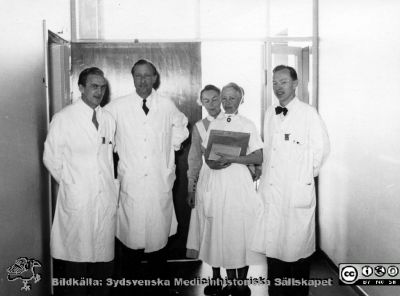 Ront på radiologiska kliniken i Lund, troligen på 1950-talet.
Tre okända läkare och två SSSH-sjuksköterskor  går rond på radiologiska kliniken i Lund. Den bortre sjuksköterskan är  Anni Jonasson (1913 - 1993). Foto troligen på 1950-talet. Läkaren längst till höger finns också i bilden SMHS06543. Från Syster Elinas fotoalbum (Elina Holmberg?).
Nyckelord: Onkologisk;Radiologisk;Jubileumsklinik;Lasarettet i Lund;Rond