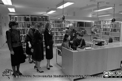 Drottning Silvia  besöker sjukhusbiblioteket i Lund i samband med Forskningens Dag 1983
Lasarettsfotograferna i Lund,  pärm  Sv/v Neg, 83:2.A. 83-11-10. Forskningens Dag 1983. Drottning Silvia informeras i sjukhusbiblioteket av en bibliotekarie om verksamheten där. Chefläkaren professor Hans Rorsman står bkom och till vänster ses  hovdamer och personal från biblioteket. Från negativ
Nyckelord: Lasarettet;Lund;Universitetssjukhuset;USiL;Forskningens Dag;Bibliotek