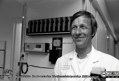 Åke Andrén-Sandberg på akutmottagningn i Lund 1985
Lasarettsfotograferna i Lund,  pärm  Sv/v Negativ, 1985. 85/40:1. Interiör från akutmottagningens, rimligen nyrenoverad. Kirurgöverläkare Åke Andrén-Sandberg, akutmottagningens. Från negativ
Nyckelord: Lasarettet;Lund;Universitetssjukhuset;USiL;Akutmottagningen;Kirurgi