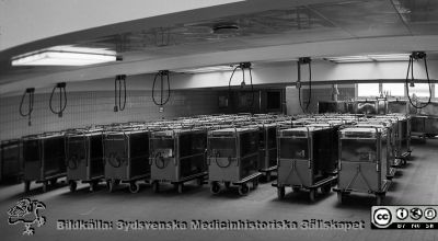 Matvagnar i nya centralköket, troligen 1960
Lasarettsfotograferna i Lund,  pärm,  96+97 (?). 14.  Nya centralköket, färdigt i första etappen 1960 och den andra 1964. Uppställningsplats för matvagnar. Foto troligen från 1960. Kanske reprofoto. Från negativ
Nyckelord: Lasarettet;Lund;Universitetssjukhuset;USiL;Centralkök;Transport;Matvagnar