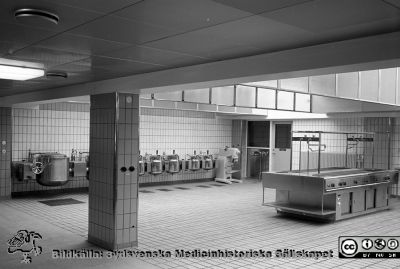 Nya centralköket i Lund 1960 eller 1964
Lasarettsfotograferna i Lund,  pärm,  96+97 (?). 14.  Nya centralköket, färdigt i första etappen 1960 och den andra 1964. Kokgrytor mm. Foto troligen från 1960. Kanske reprofoto. Från negativ
Nyckelord: Lasarettet;Lund;Universitetssjukhuset;USiL;Centralkök