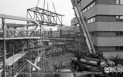 Bryggan mellan centralblocket och onkologiska kliniken sätts upp 1988-04-29
Lasarettsfotograferna i Lund.  Blandade negativ, omärkta år 1988-1995 (lösa negativhållare). Bryggan mellan centralblocket och onkologiska kliniken sätts upp 1988-04-29. Den kom aldrig till avsedda användning, för det blev aldrig någon onkologisk avdelning i centralblocket. Från negativ.
Nyckelord: Lasarettet;Lund;Universitetssjukhuset;USiL;Onkologiska;Kliniken;Centralblocket;vergång;Brygga